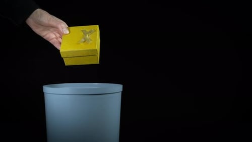 Discarding Gift into Trash Can