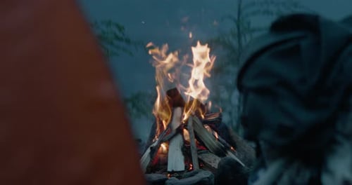 Campfire burning strong at dusk camping spot