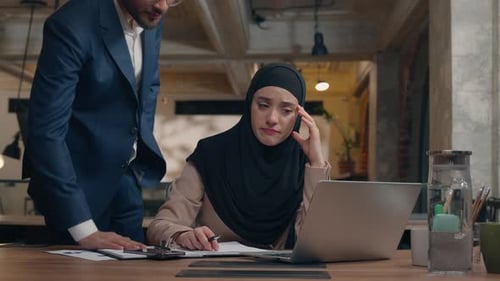 Woman with Headscarf Relieved by Coworker's Insight