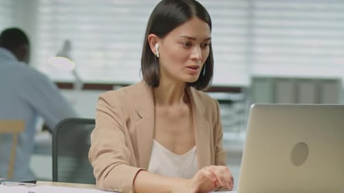 Businesswoman Talking via Video Call on Laptop in Office