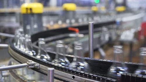 Automated bottling conveyor system sorting beer bottles in modern factory