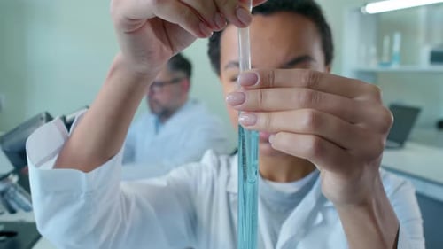 Scientist Uses Pipette in Medical Laboratory