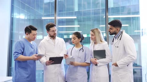 Group of doctors talking standing in a hospital office. Professionals engaged in teamwork