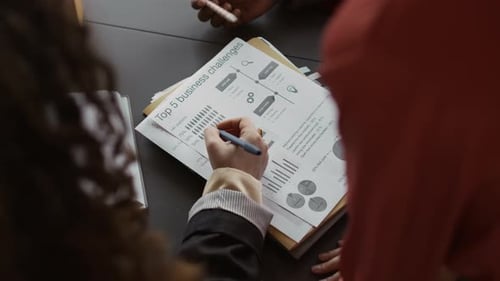 Business Team Analyzes Charts at Office Table