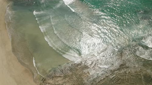 Aerial view of Ostional beach in Costa Rica showing gentle ocean waves and sandy shore