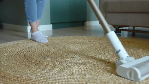 Vacuuming a Beige Round Rug in Living Room