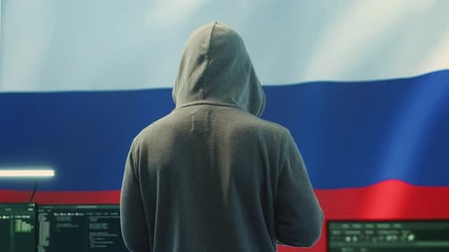 Un hacker russe travaillant dans une salle de piratage gouvernementale avec le drapeau russe