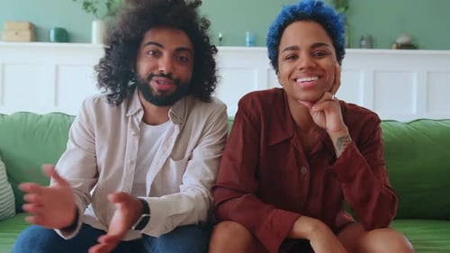 Two Friends Talking on Couch Indoors