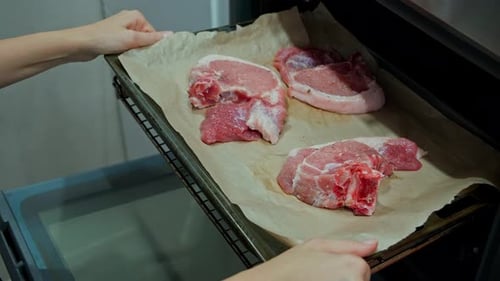 Home cooking juicy pieces of raw fresh pork meat in the oven