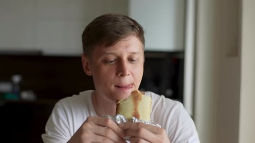 Closeup Face of Satisfied Hungry Man Eating Delicious Sandwich at Home Happy Male Enjoying