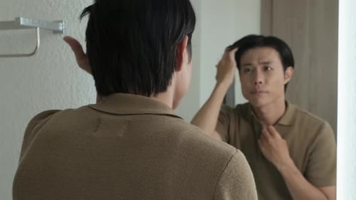 Man Fixing His Hair in the Mirror