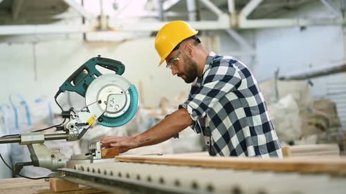 Procédé de coupe du bois. Ouvrier industriel dans un entrepôt.