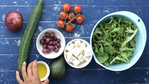 Zeitraffer von Frauenhänden bei der Zubereitung eines griechischen Salatrezepts, fertig