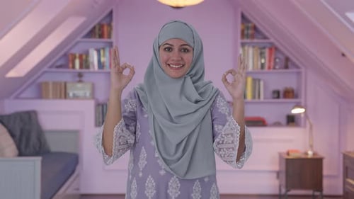 Glückliche muslimische Frau zeigt Okayschild