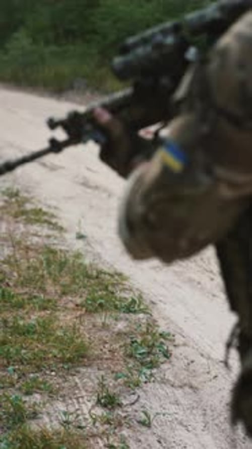 Armed with Special Equipment and Weaponry a Soldier is Moving Along a Dirt Road in a Wooded Area