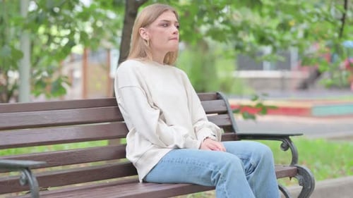 Woman Sits on Park Bench Checking Watch