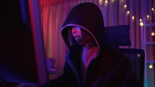 Teenage Hacker Typing Code in a Dark Room