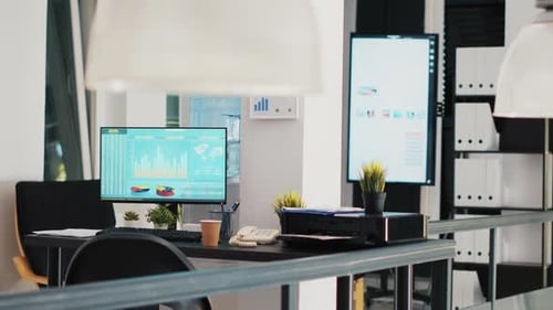 Office with Stock Exchange Listings and Business Charts Displayed in Background
