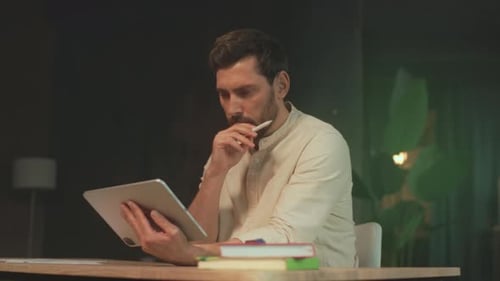 Visual Artist Engaged in Detailed Sketching Using Digital Tools Amidst Productive Studio Environment