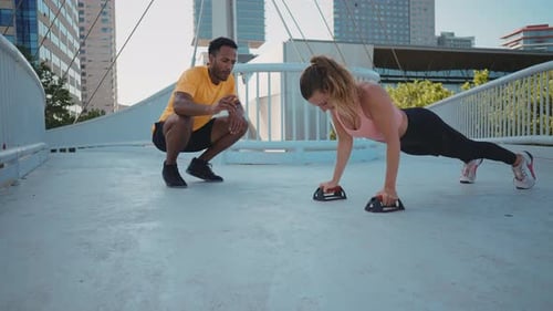 Woman Exercising on Bridge with Fitness Trainer
