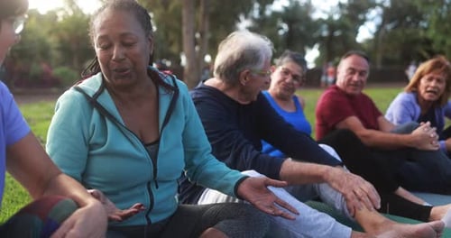 Multiracial seniors enjoying fun outdoor exercises in city park USA on a sunny day