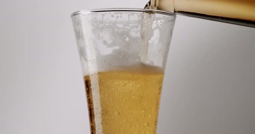 Beer Pouring Into Glass on White Background