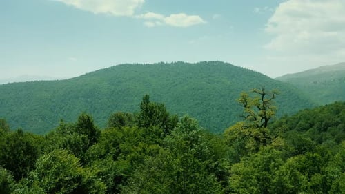 Drone Footage of a Green Mountain Landscape with a Village – 4K Aerial