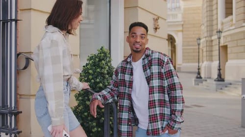 Multiethnic Couple in Love A Couple is Standing on the Street Next to Beautiful Houses and Talking