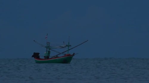 Fishing Boats in Thailand wait in the middle of the ocean for dark to come so they can turn on their