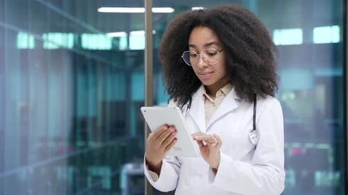 Young Woman Doctor Using Tablet in Modern Hospital