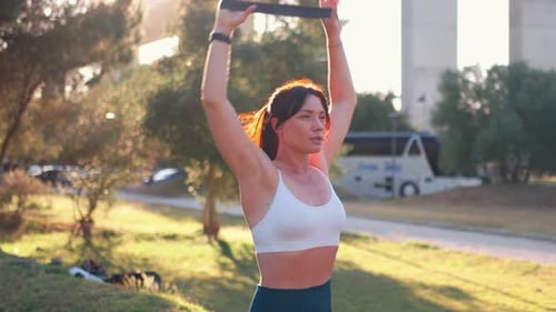 Athletic Female Exercising with Resistance Bands in Park