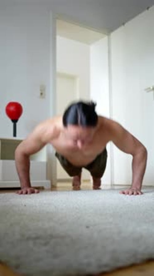 Muscular Man Doing Push-ups on Carpet Indoors