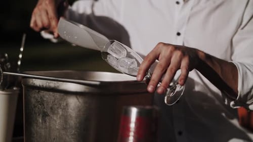 El camarero vierte hielo en el vaso