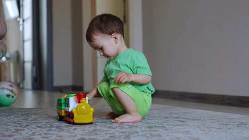 Cute Child Playing with a Toy Train Indoors