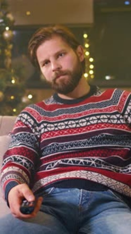 Musing Gentleman Sitting Comfortably on Couch Surrounded By Wrapped Presents and Serene Ambiance
