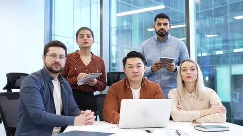 Portrait of group multiethnic business team sitting at workplace in modern office. Successful