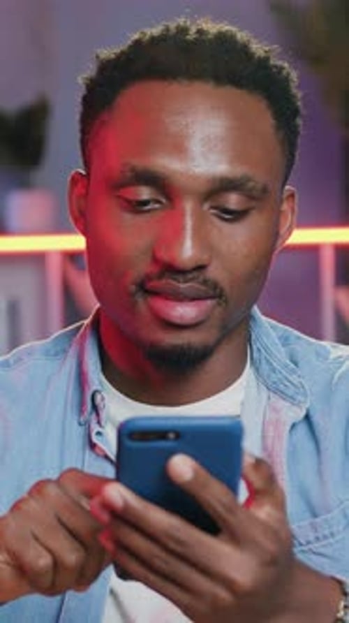 Smiling Man Using Mobile Phone in Interior Setting