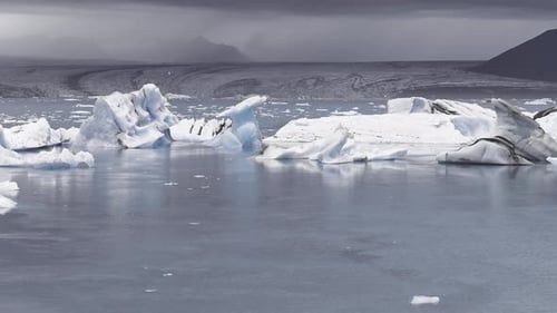 Luftaufnahme der Gletscherlagune mit Eisbergen im bewölkten Himmel Islands