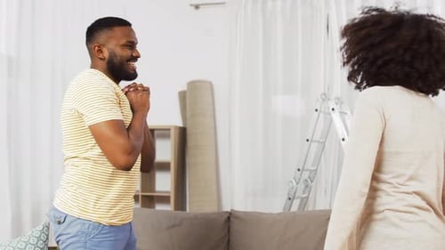 People and Real Estate Concept - Happy African American Couple with Stuff