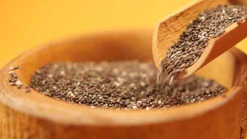 Chia Seed Pouring From a Wooden Spoon