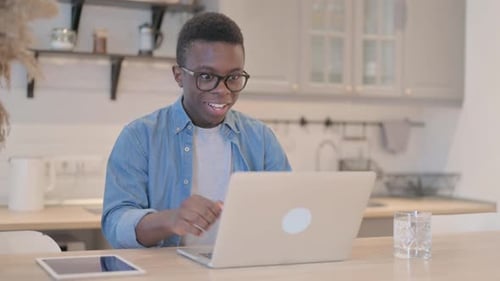 Man Cheers at Laptop in Home Office
