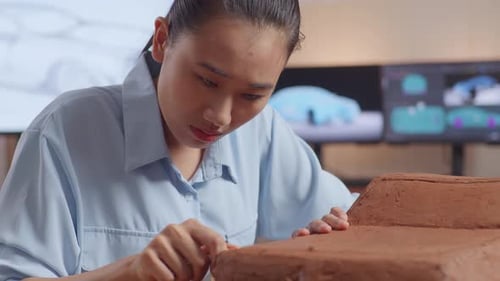 Close Up Of Asian Woman Automotive Designer Works On The Sculpture Of Car Clay