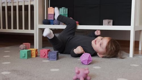 Happy Baby Playing with Soft Blocks on Carpet
