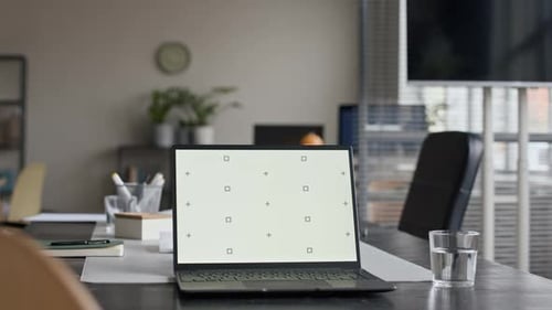 Computadora portátil Chroma Key en la mesa de conferencias de una oficina moderna de planta abierta