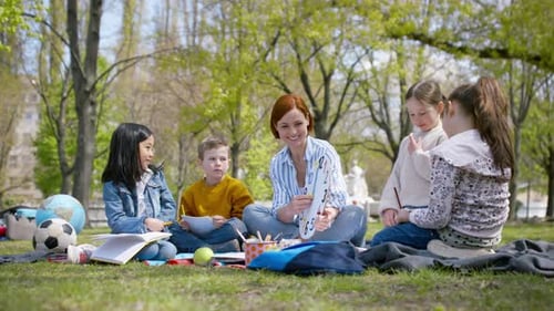 Sunny day learning with teacher and children in city park education concept