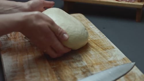 Contour Effect of Rolling Out Fresh Dough for Pizza on Wooden Cutting Board