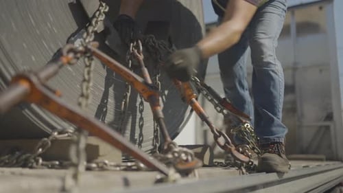 Trucker sichert Ladung an seinem Anhänger mit einem Schraubenschlüssel