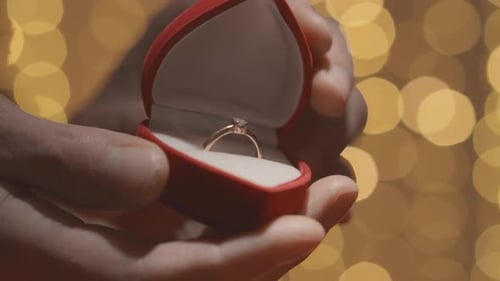 Closeup of Hands Opening a Red Box for Wedding Ring and Jewelry