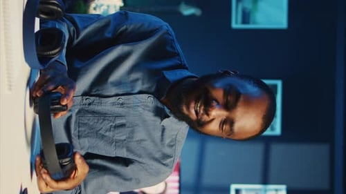 Man at Computer Looks at Headphones