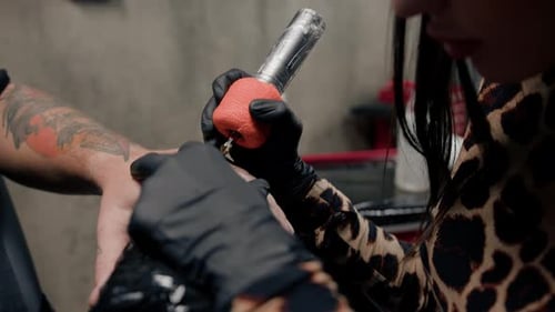 Close-up - a needle penetrates the skin, tattoo, tattoo studio